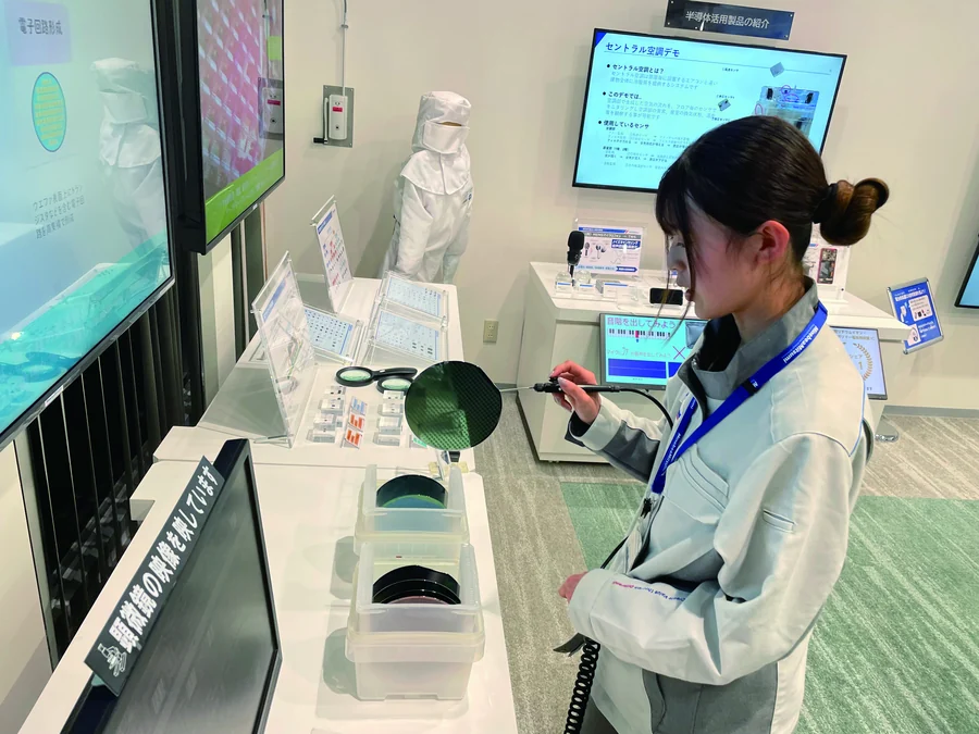 クリーンルームでシリコンウェーハを確認する女性
