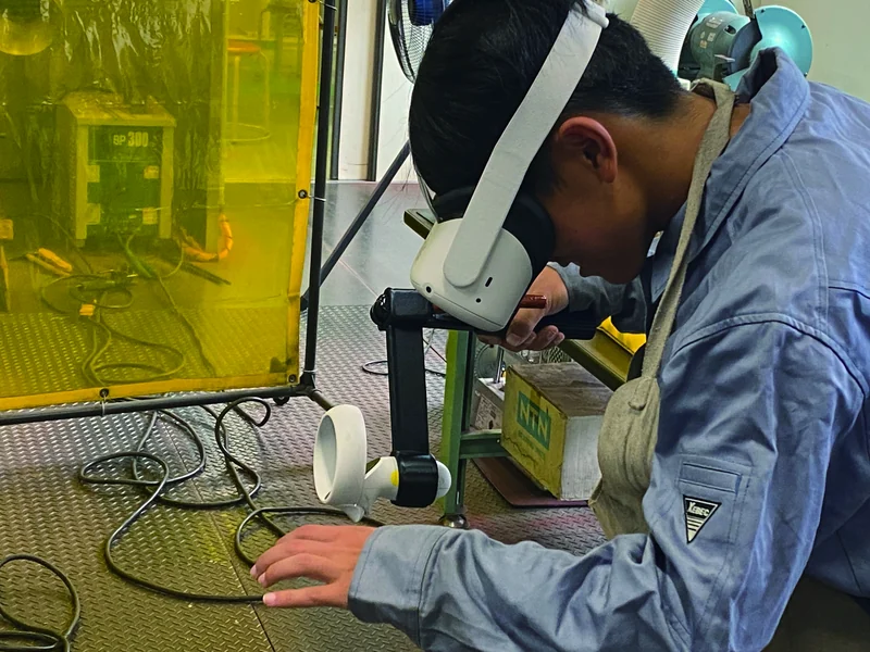 ヘッドセットを着けて溶接VRに取り組む生徒