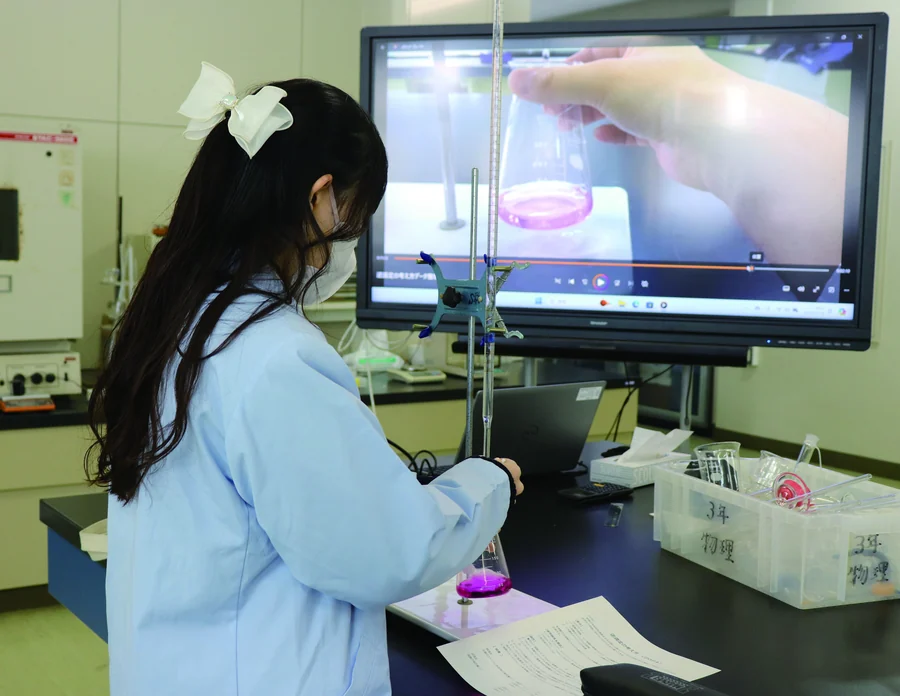 実験室のモニターを見ながら定量実習に取り組む生徒