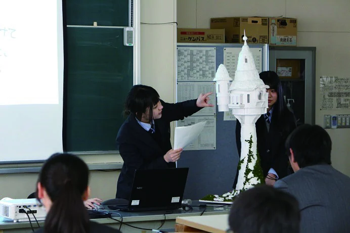 製作した模型を示しながら発表する生徒